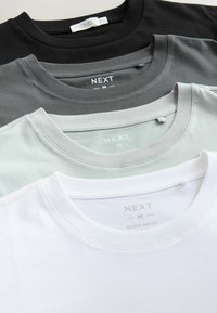 Štyri tričká s okrúhlym výstrihom naskladané, v čiernej, tmavosivej, svetlosivej a bielej farbe. Vyrobené z bavlny, s etikety zobrazenými značkou a veľkosťou.