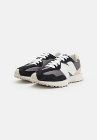 Svarta och grå sportskor i mocka och mesh-material, med en vit logotyp, kontrasterande detaljer och en texturerad gummisula.