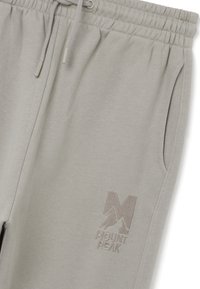 Lichtgrijze sweatpants van zacht materiaal, met een elastische tailleband met trekkoorden, zijzakken en een geborduurd "MOUNT PEAK" logo.