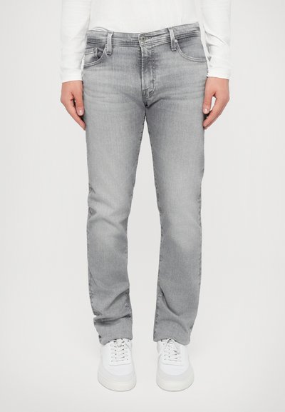 Gray denim jeans with a straight fit, two front pockets, light fading, and a zipper fly, paired with white sneakers.