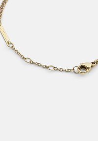 Bracciale in oro con anelli intrecciati e chiusura a moschettone. Include un tag rettangolare inciso con "Daniel Wellington."