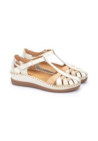 Sandalias de cuero blanco y dorado con diseño cortado, detalles de costura, correa ajustable y suela de goma marrón.