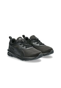 Des chaussures de sport noires avec une tige en tissu texturé, des lacets plats, une semelle rembourrée et un design épuré avec un logo sur la languette.
