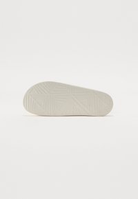 Talpă de cauciuc albă cu un model geometric de striație, vârf rotunjit și textură netedă. Design curat fără logo-uri sau elemente decorative vizibile.