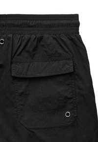 Schwarze Shorts mit elastischem Bund, einer Gesäßtasche, strukturiertem Stoff und einem Metallösen-Detail in der Nähe der Tasche.
