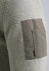 Grijs gebreid sweater met een gestructureerd patroon, voorzien van een contrasterend grijze stoffen patch op de elleboog, die stikwerk en een merklabel toont.