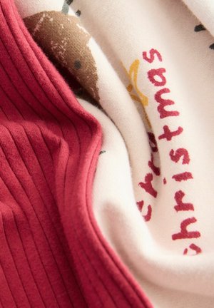 Roter gerippter Stoff, der über cremefarbenem Stoff liegt und ein braunes Igelmotiv sowie roten Text mit der Aufschrift "Frohe Weihnachten" zeigt. Weiche Textur.