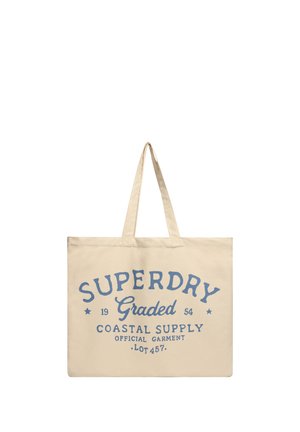 Beige taske med to håndtag, blåt tekst "Superdry Graded Coastal Supply Official Garment Lot 457" trykt på fronten.