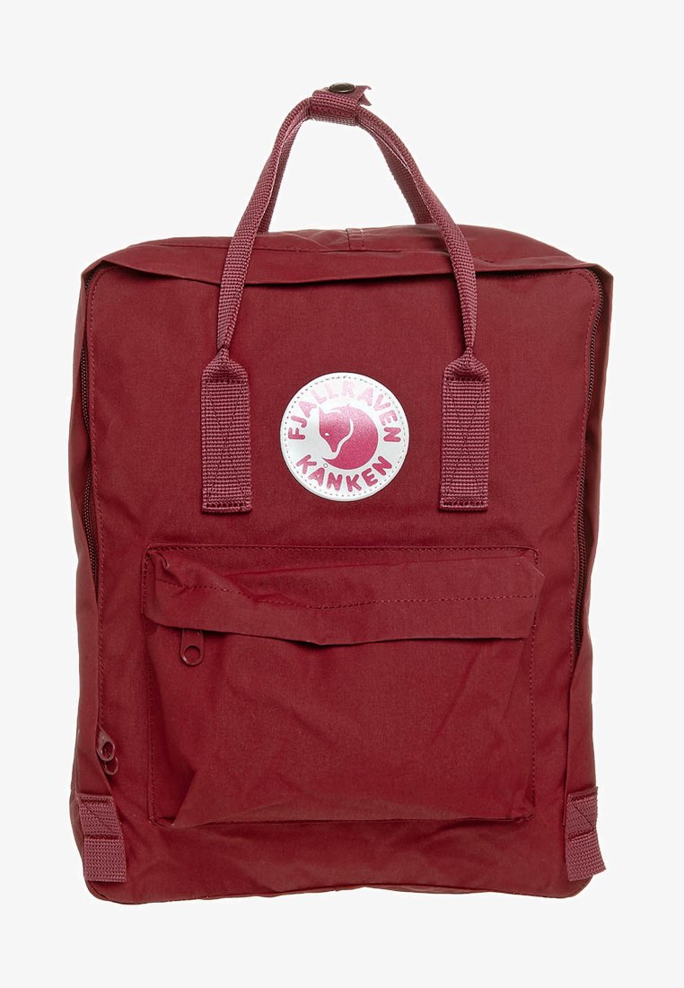 Κόκκινο σακίδιο Fjällräven Kanken φτιαγμένο από ανθεκτικό ύφασμα, με ορθογώνιο σχήμα, μπροστινή τσέπη, διπλούς επάνω χειρομάκους και κυκλικό λογότυπο.
