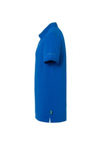 Blå kortærmet polo skjorte med krave, "uhlsport" logo på ærmet og et lille grønt mærke nær kanten, vist fra højre side.