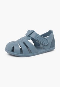 Blå gumm sandal med åben tå-design, justerbar rem og udskæringsmønstre på overdelen for ventilation. Tekstureret indersål for bedre greb.