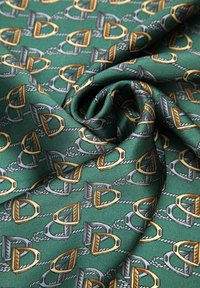 Groen stof met een patroon van herhalende gouden en grijze zadelvormen die met touwen zijn verbonden, met een gladde textuur.