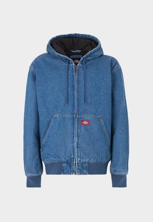 Giacca con cappuccio in denim color azzurro chiaro, con cerniera frontale, due tasche laterali e fodera interna nera. Patch con logo rosso vicino alla cerniera.