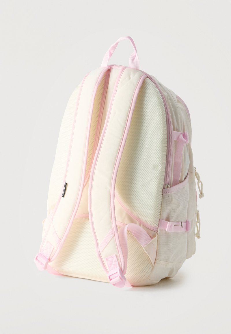Zaino crema e rosa chiaro con spallacci imbottiti, pannello posteriore in rete, tasca laterale e maniglia superiore mostrato da dietro.