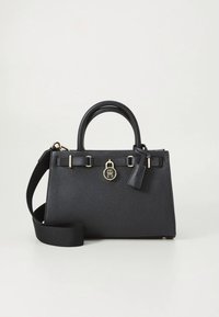 Crna kožna torba s dvostrukim ručkama, zlatnim metalnim detaljima, bočnim remenom i teksturiranom površinom. Opremljena privjeskom s logotipom i strukturiranim oblikom.