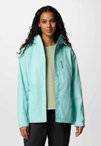 Giacca leggera turchese con cappuccio, dotata di una tasca con zip sul petto e polsini elasticizzati, indossata sopra una maglietta verde chiaro. Texture liscia.