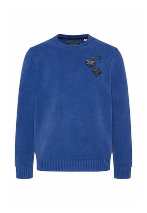 Suéter azul de punto con cuello redondo, puños y dobladillo de canalé, que presenta tres parches de tela cosidos en el pecho. Textura suave.