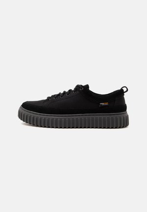 Μαύρο sneaker χαμηλού τύπου με παχιά γκρι σόλα με ανάγλυφα αυλάκια και κλείσιμο με κορδόνια, που διαθέτει μικρή υφασμάτινη ετικέτα στο πλάι και θηλιά στο τακούνι.