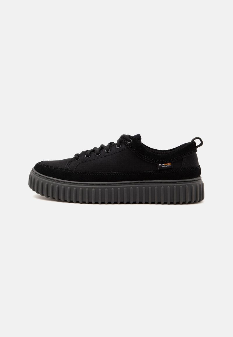 Μαύρο sneaker χαμηλού τύπου με παχιά γκρι σόλα με ανάγλυφα αυλάκια και κλείσιμο με κορδόνια, που διαθέτει μικρή υφασμάτινη ετικέτα στο πλάι και θηλιά στο τακούνι.