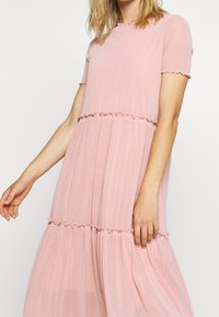 Różowa, teksturowana sukienka z krótkimi rękawami, falbanami i warstwowym krojem, o subtelnym połysku i płynnej sylwetce.