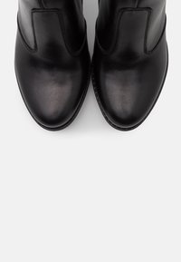 Black leather ankle boots with a smooth finish, rounded toe, and elastic side panels. Features a stitched sole detail for durability.