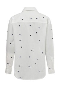 White long-sleeve shirt featuring navy blue heart-pattern embroidery, classic collar, and buttoned cuffs. Soft, textured fabric.