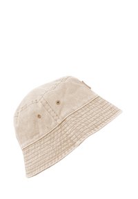 Beige cotton bucket hat with a textured surface, two ventilation holes on the sides, and a ribbed brim. No visible logos or accents.