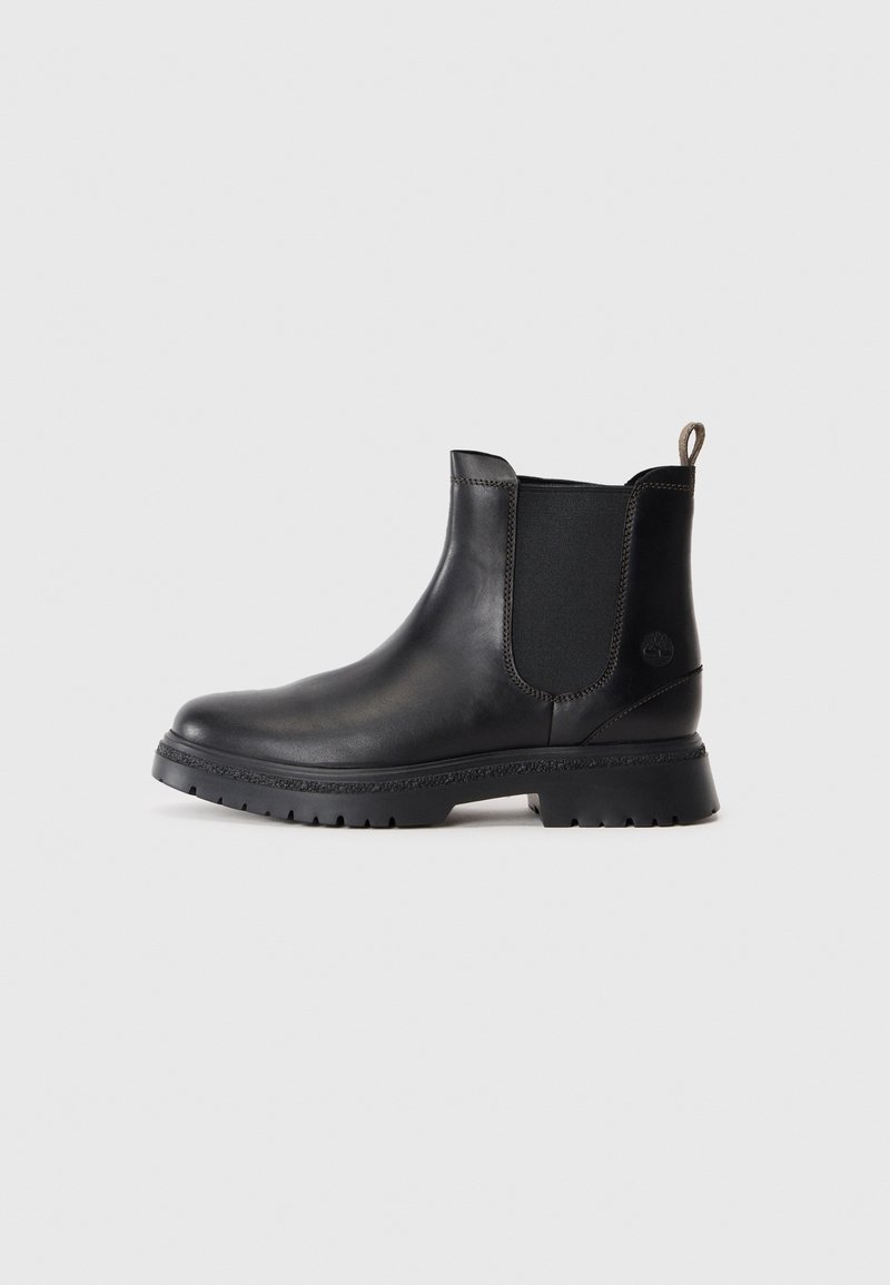 Bottine en cuir noir avec panneau élastique sur le côté, languette de tirage au talon et semelle robuste, vue de profil sur fond clair.