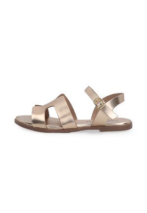 Metallic gold Sandalen mit ausgeschnittenem Design, verstellbarem Knöchelriemen und flacher Sohle. Glatte Textur und kombiniert mit minimalen Hardware-Akzenten.