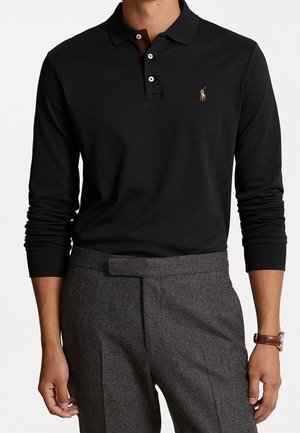 Black long-sleeve polo shirt with a collar and three buttons, featuring a small embroidered logo. Paired with gray tailored trousers.