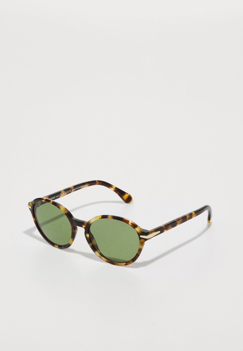 Occhiali da sole tartaruga con lenti verdi, caratterizzati da montature tonde e sottili accenti dorati sulle aste. Texture liscia e design leggero.