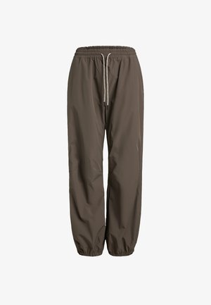 Hnědé, lehké a voděodolné kalhoty s elastickým pasem a stahovací šňůrkou. Úzký střih se staženými lemy u kotníků.