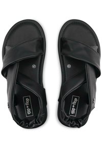 Black sandals featuring crossed straps in soft material, rounded toe, cushioned footbed, and elastic heel for added comfort. Size 37 visible.