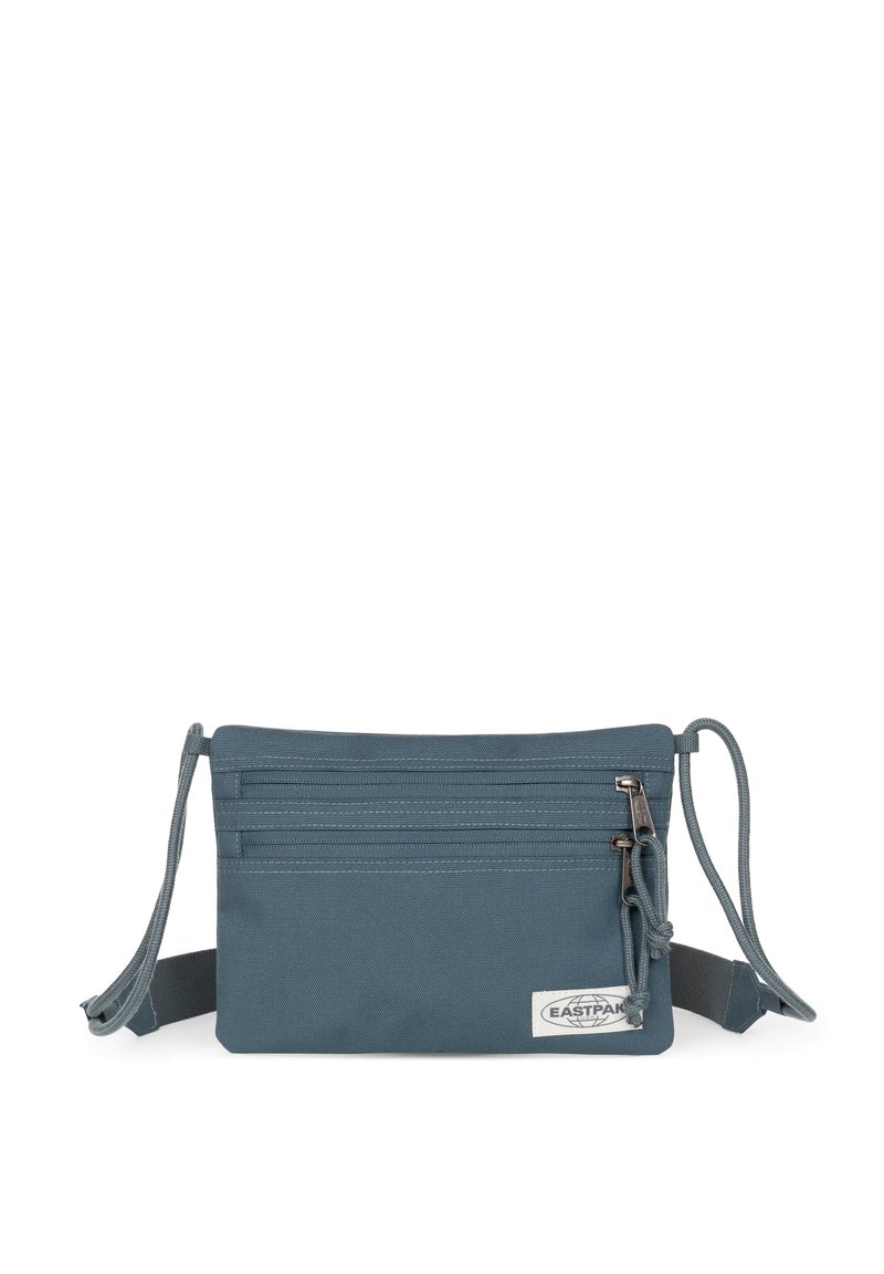 Bolso cruzado de tela azul con múltiples compartimentos con cremallera, correa ajustable y superficie texturizada. Presenta una etiqueta de logo en la parte frontal.