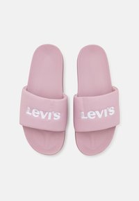 Chanclas rosas de acabado texturizado, con una tira ancha grabada con el logo de Levi's en blanco. Diseño de suela plana.