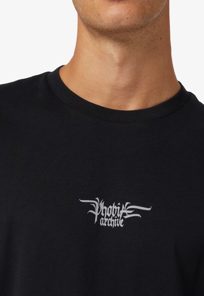 T-shirt nera in cotone con scollo rotondo. Presenta un testo grafico bianco "Phobi archive" nella zona del petto. Design semplice.