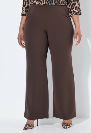 Brown wide-leg pants with a smooth texture and a high waist, paired with a leopard print top and pointy-toed, animal print heels.