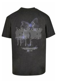 Sort kortærmet t-shirt med et stort grafisk motiv af en lilla sommerfugl og stiliseret tekst på ryggen. Blødt bomuldsstof, afslappet pasform.