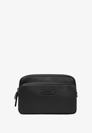 Bolsa de aseo negra de cuero con dos compartimentos con cierre, que presenta una superficie texturizada y un pequeño detalle de logo en la parte frontal.