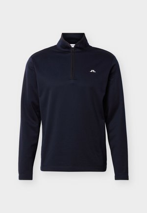 Námořnicky modrý dlouhý rukáv s polovičním zipem u límce a malým bílým logem na levé straně hrudi.