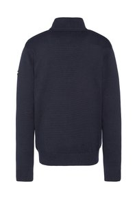 Granatowy sweter z dzianiny z wysokim kołnierzem i prążkowanymi mankietami. Na lewym ramieniu małe logo. Gładka faktura, dopasowany fason.