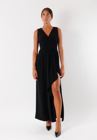 Vestito lungo nero con design avvolgente, scollo a V profondo e alto spacco laterale. Realizzato in tessuto morbido, presenta linee minimaliste e un'elegante silhouette.