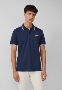 Dunkelblaues Poloshirt aus Baumwolle mit einem klassischen Kragen, weißen Streifen an den Ärmeln und einem kleinen Logo auf der Brust.