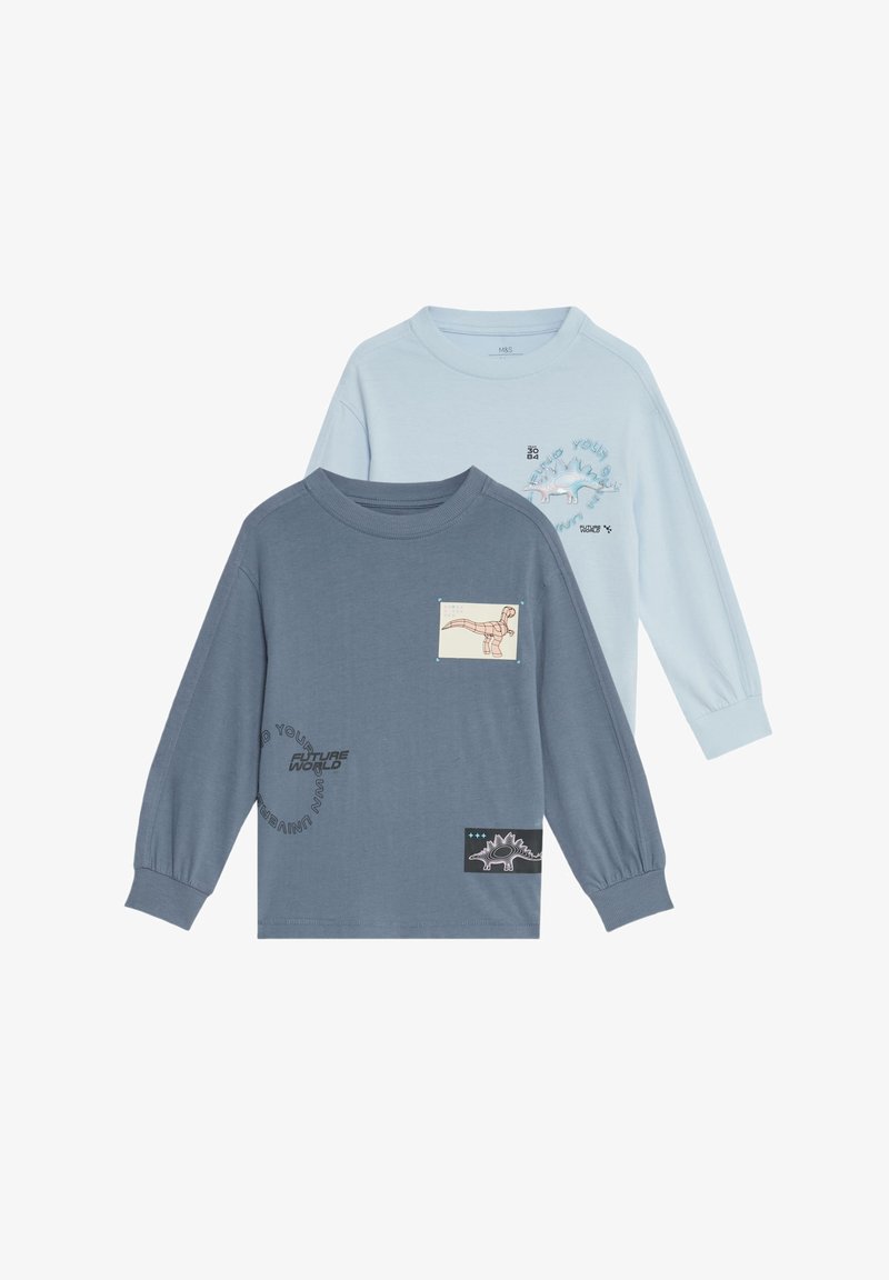 Due magliette a maniche lunghe: una azzurro chiaro con grafiche di dinosauri, l'altra blu scuro con testo e dettagli di toppa a forma di dinosauro. Materiale in cotone.