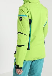 Jasně zelená zateplená bunda s modrými akcenty a černými detaily, s kapsou na zip na horním rameni a otvory na palce.