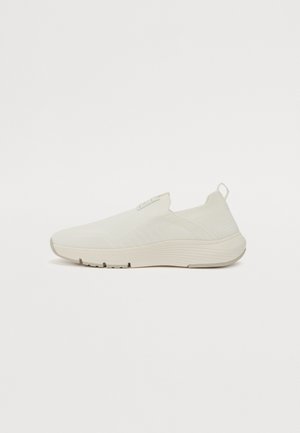 Bílé slip-on tenisky s texturovaným svrškem, elastickým límcem a polstrovanou podešví. Minimalistický design bez viditelných tkaniček.