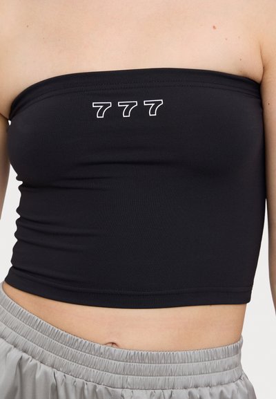 Croptop noir sans manches en tissu extensible, présentant un imprimé blanc "777" à l'avant. Texture lisse avec une coupe ajustée.