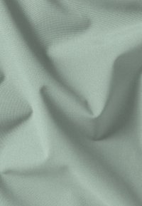 Lichtgroene stof met een gladde, zachte textuur, voorzien van subtiele plooien en een gelijkmatig, egaal oppervlakpatroon.