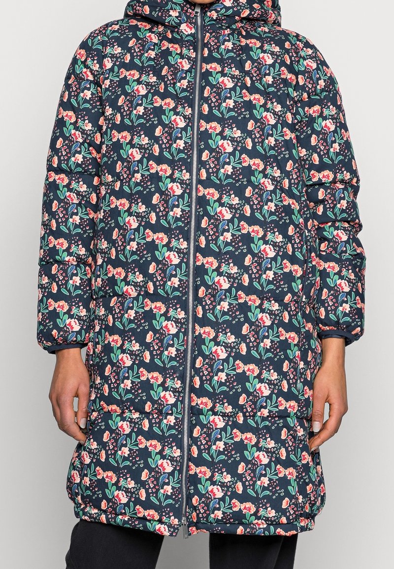 Polstret parka med marineblå baggrund, med et blomstermønster i rødt, pink og grønt. Indeholder en fuld lynlås foran og hætte.