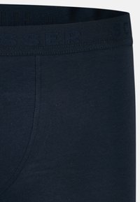 Marinblå bomullskalsonger med en strukturerad elastisk midjeband som har präglad logotyp. Slät tygkvalitet med en åtsittande passform.